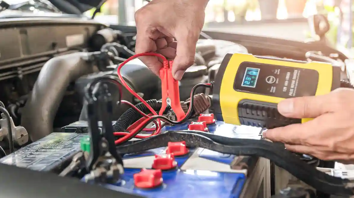Person Checking on a Car Battery