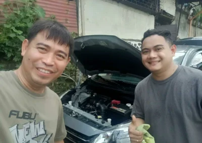 Technician replacing a green Amaron car battery during on-site service in Rizal.