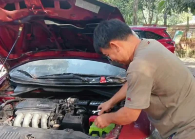 Young technician installing a new Amaron car battery at Jet Battery Trading store in Rizal.