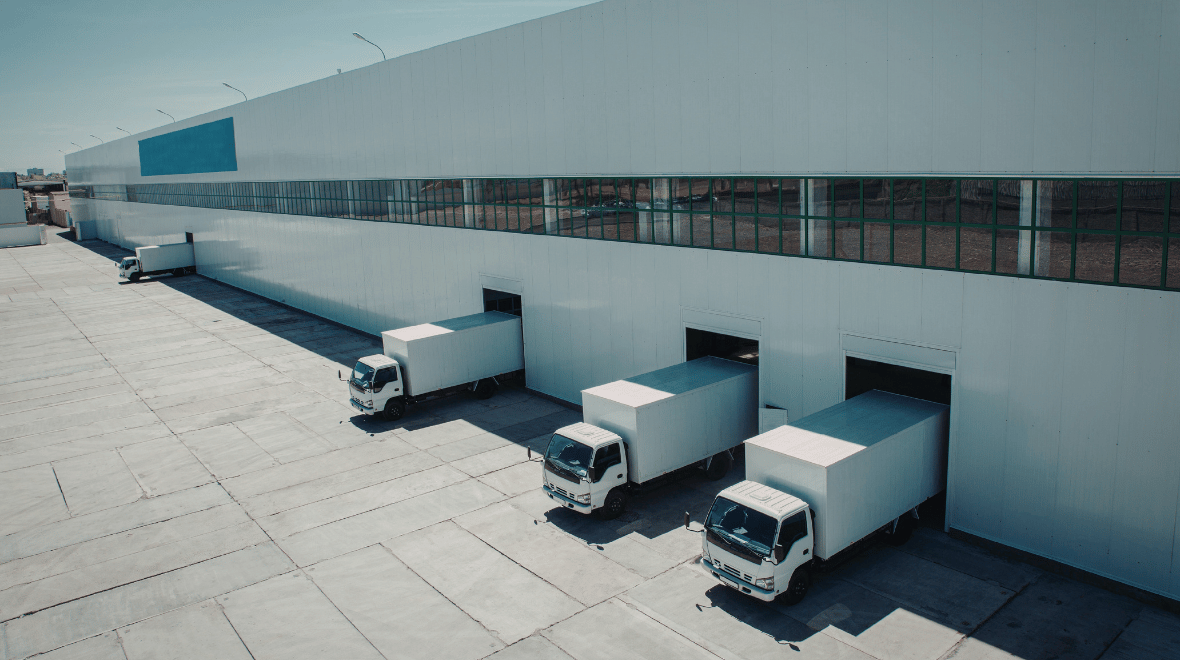 White-delivery-trucks-parked-at-loading-docks-of-a-large-modern-warehouse
